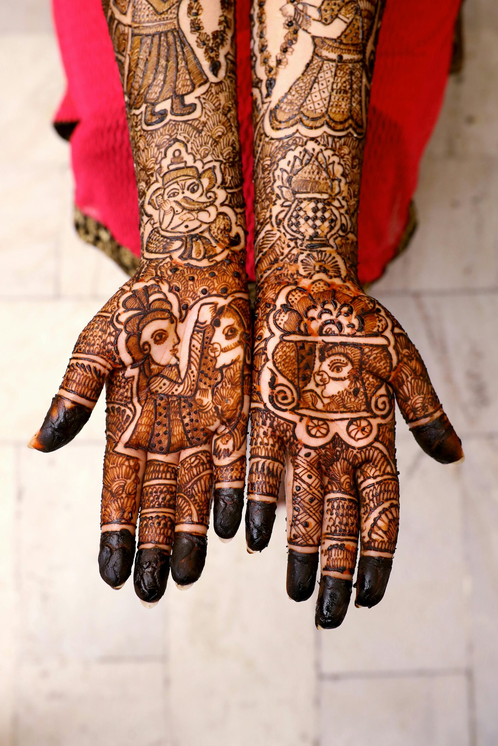 Beautiful mehndi art covers the hands of an adult woman, showcasing traditional cultural patterns.